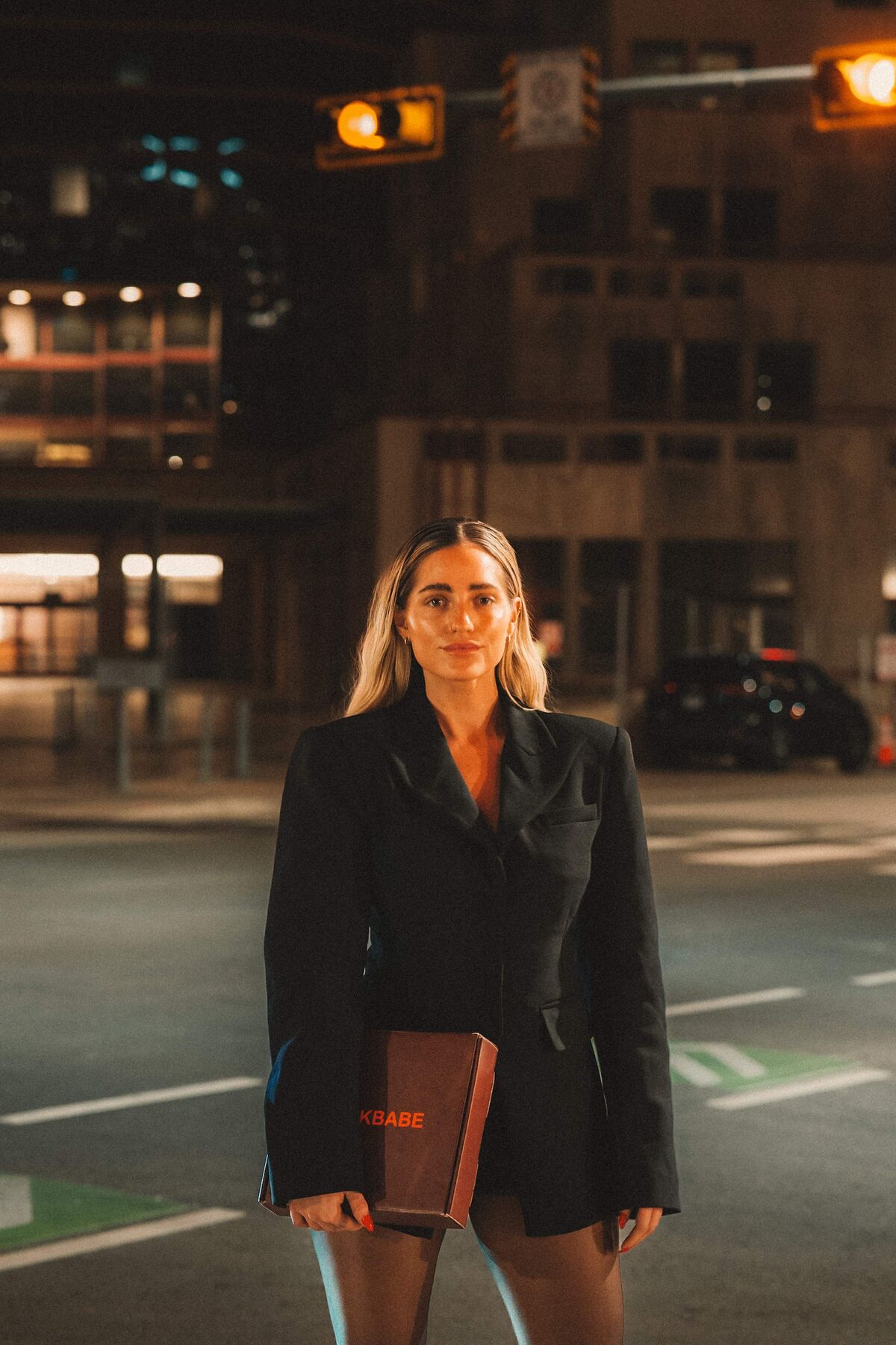 Casey urban night portrait with SLICKBABE box — downtown editorial