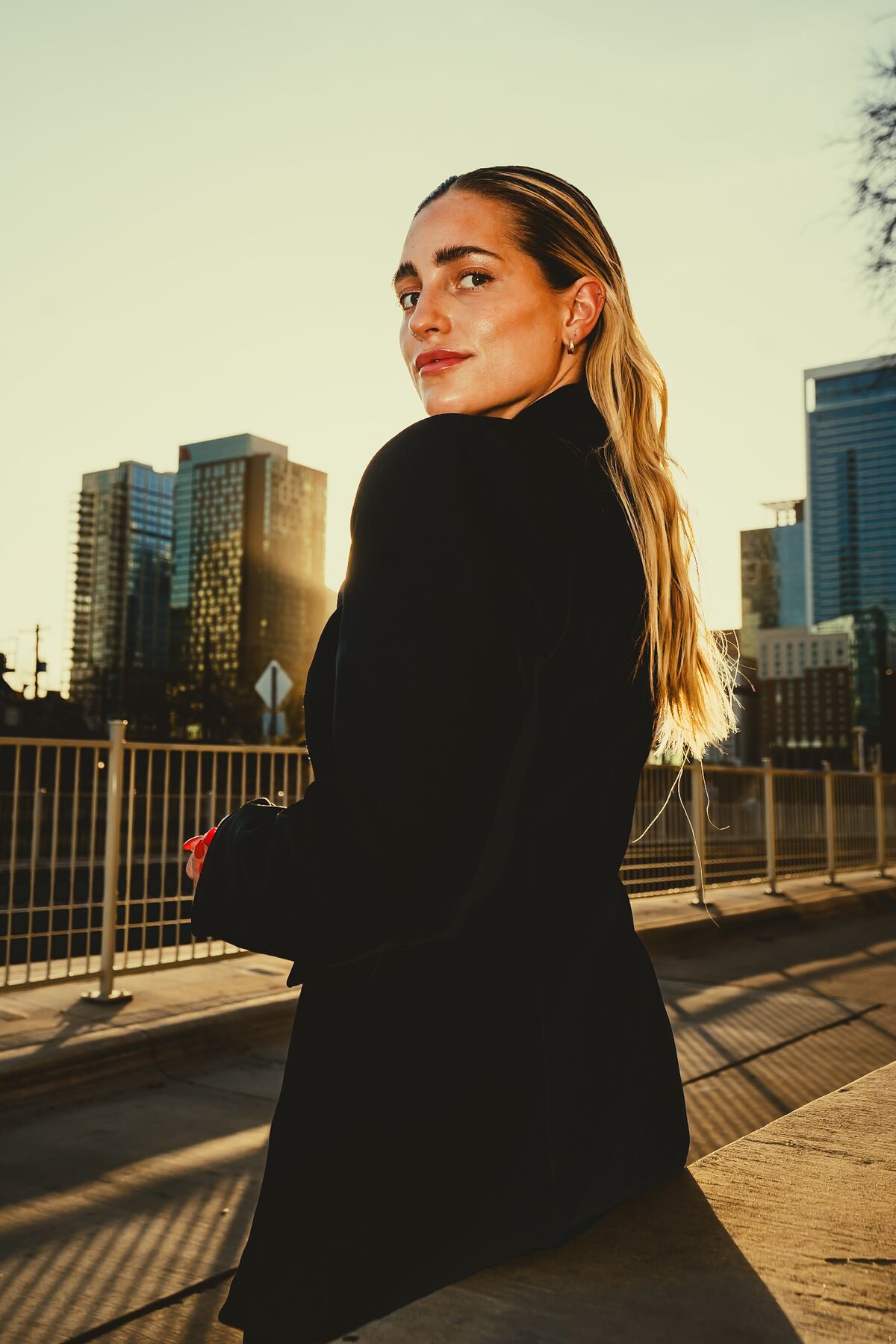 Casey golden hour skyline portrait — slicked back hair, looking over shoulder
